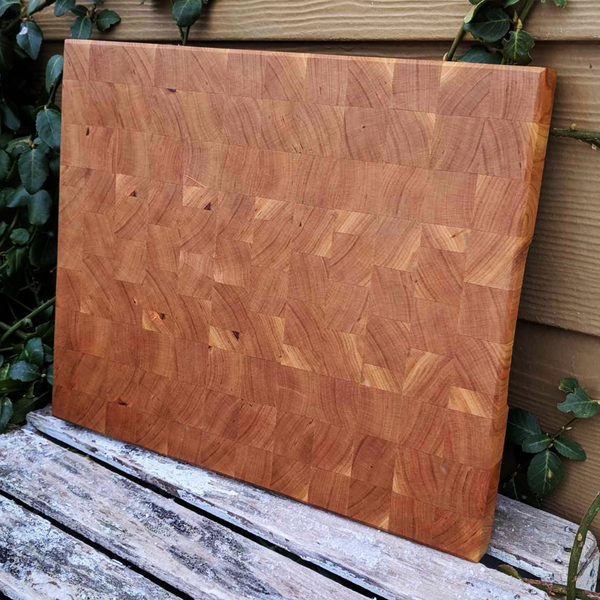 Top-down view of cherry end grain cutting board showcasing wood pattern and bevel