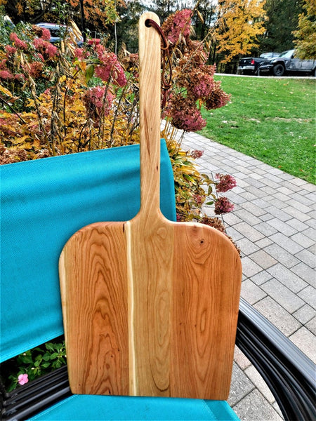 Handcrafted wood pizza peel and pizza cutter.