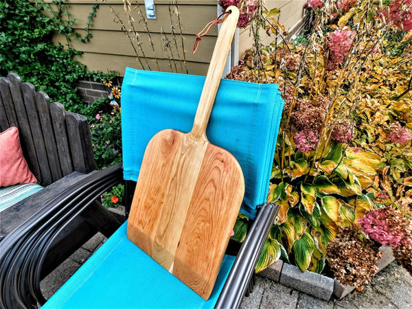 Handcrafted wood pizza peel and pizza cutter.