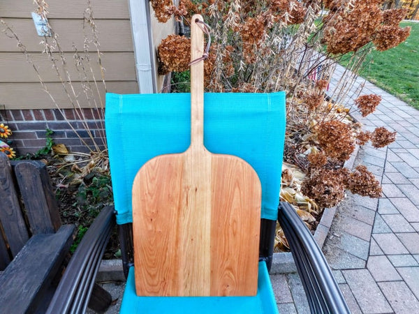 Handcrafted wood pizza peel and pizza cutter.