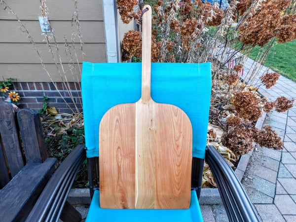 Handcrafted wood pizza peel and pizza cutter.