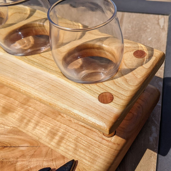 Cherry wood beer flight board with glasses and sauce cups.