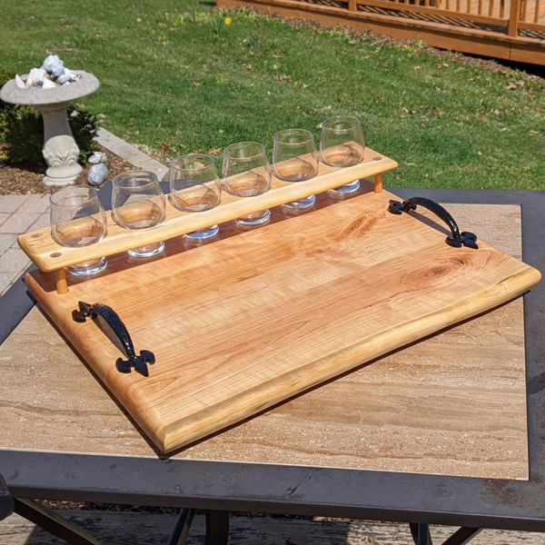 Cherry wood beer flight board with glasses and sauce cups.