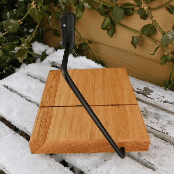 Cherry Wood cheese slicing board with clear rubber grip feet.