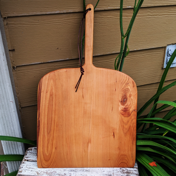 Close-up of cherry pizza peel face showcasing natural wood grain and satin finish