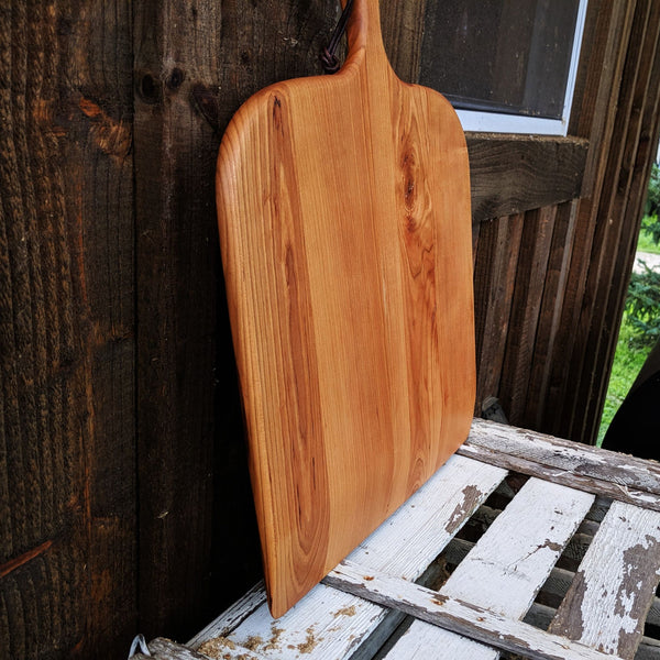 Flat lay of cherry pizza peel showing full surface and handle from above
