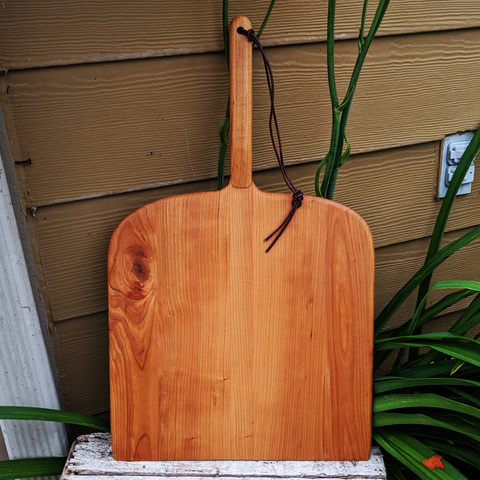 Front view of handcrafted Cherry Wood pizza peel with handle and leather strap