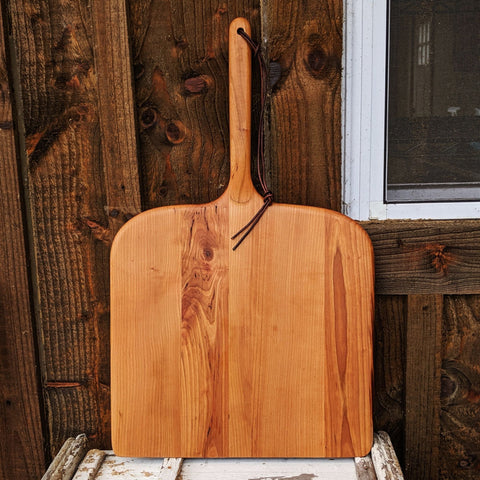 Cherry wood pizza peel front view with long handle and leather strap