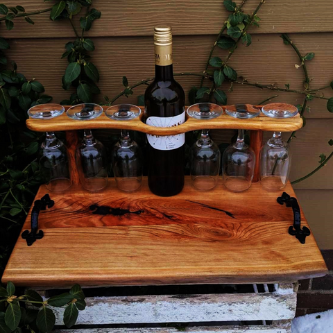Front view showing spalted cherry board with wine glasses and cast iron handles