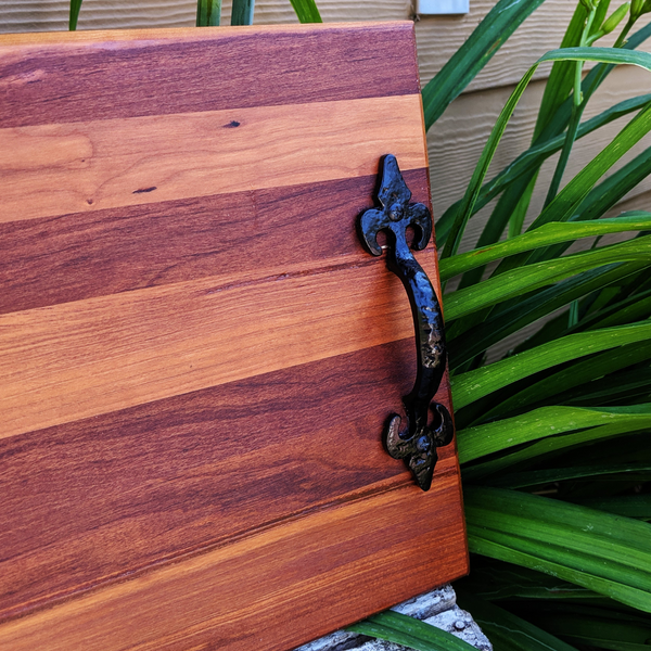 Overhead flat lay of spalted cherry wood charcuterie board with handles and rubber grip feet