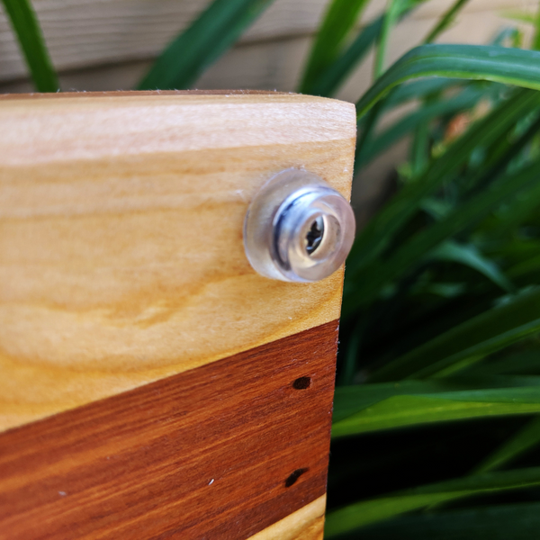 Close-up of clear rubber grip feet on spalted cherry wood charcuterie board