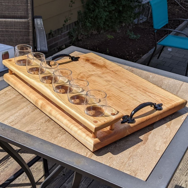 Cherry wood beer flight board with glasses and sauce cups.