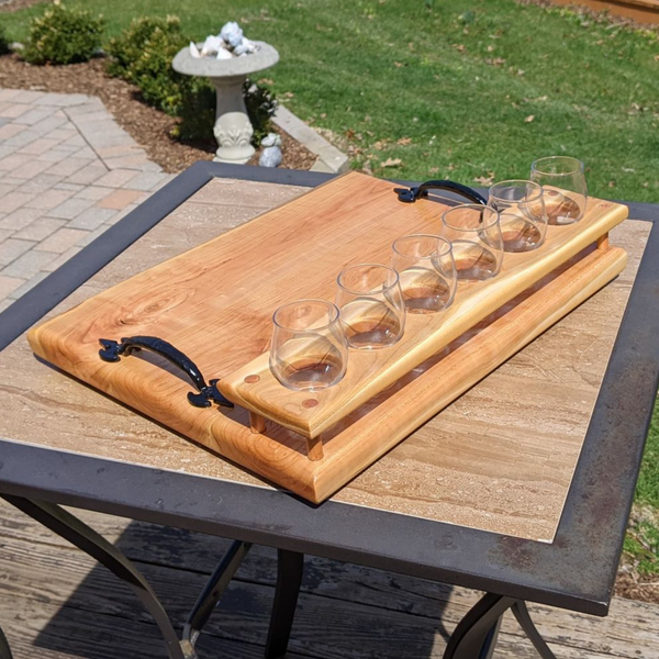 Cherry wood beer flight board with glasses and sauce cups.