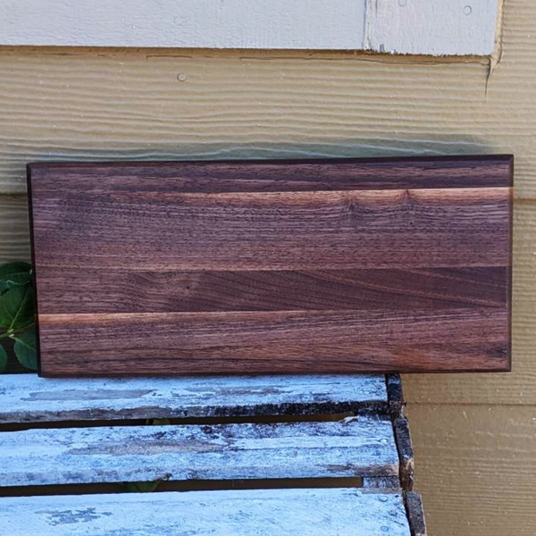 Black walnut edge grain cutting board with beveled edge.