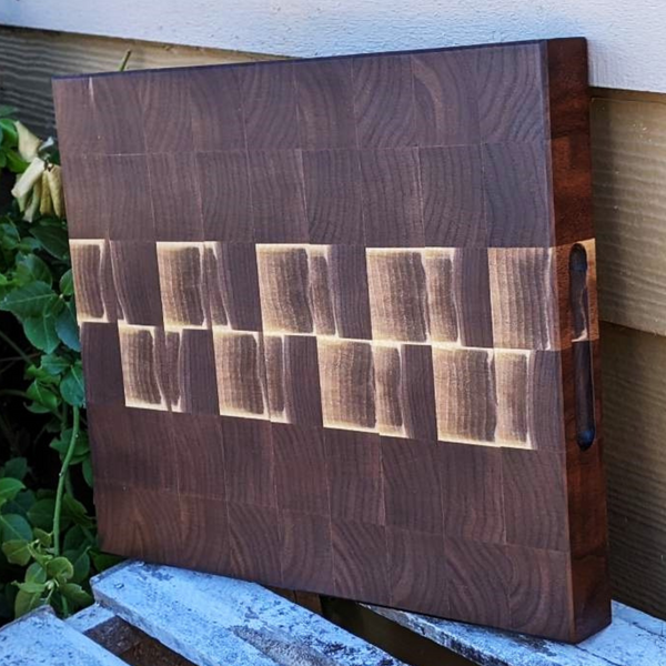 Black walnut wood end grain cutting board with beveled edge.