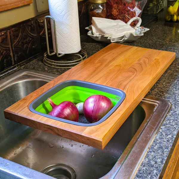 Cherry wood wooden cutting board with removable collapsivle colander strainer and clear rubber grip feet. Cherry Wood Edge Grain Cutting Board with Colander and Clear Rubber Grip Feet