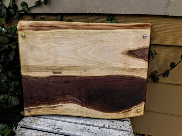 Large Black Walnut charcuterie board tray with heavy duty cast iron handles, and clear rubber grip feet.