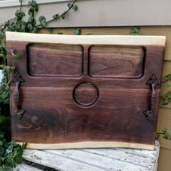 Large Black Walnut charcuterie board tray with heavy duty cast iron handles, and clear rubber grip feet.