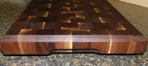 Black Walnut end grain cutting board with clear rubber grip feet and hand grooves. Handmade by Springhill Millworks.
