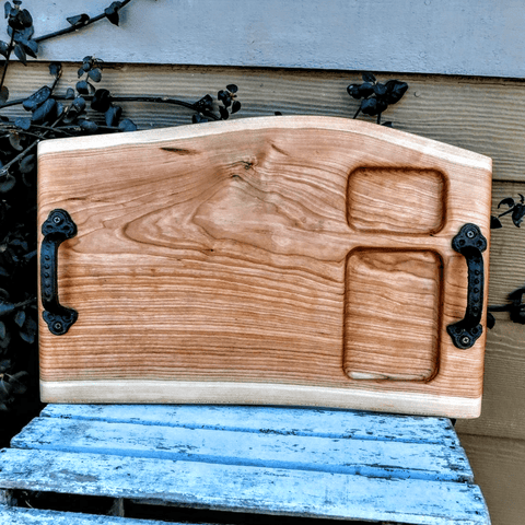 Cherry Wood charcuterie board tray with heavy duty cast iron handles and clear rubber grip feet.