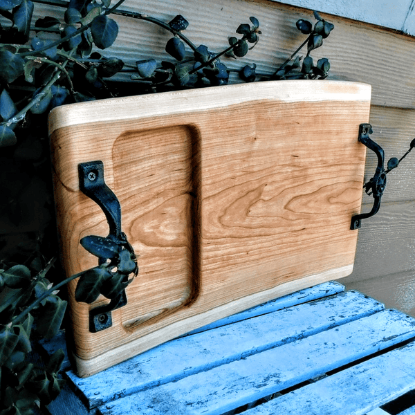 Cherry Wood charcuterie board tray with heavy duty cast iron handles and clear rubber grip feet.