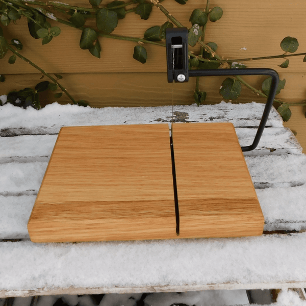 Cherry Wood cheese slicing board with clear rubber grip feet.