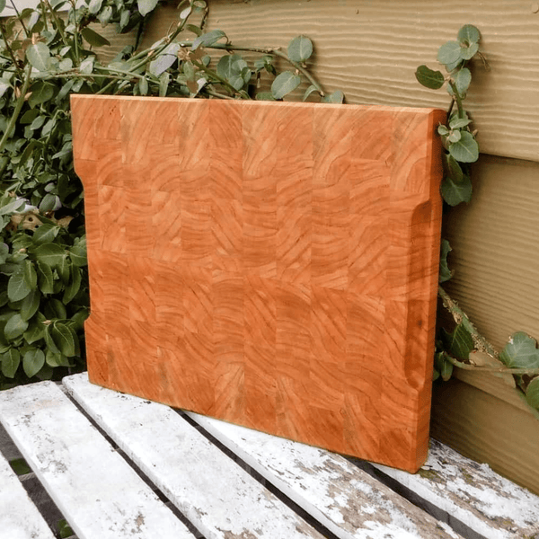 End grain cutting board with hand grooves on sides for easy handling. Finished in a food grade beeswax and mineral oil mixture.