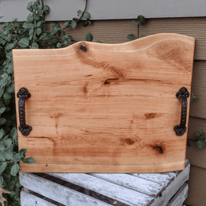 Large Cherry Wood charcuterie board with heavy duty cast iron handles and clear rubber grip feet.