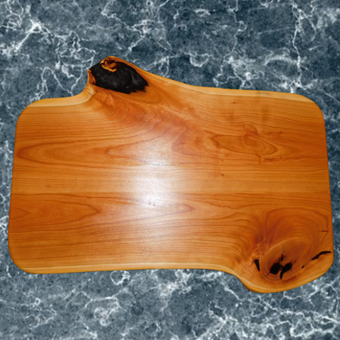 Cherry Wood charcuterie board with knots sealed using translucent epoxy to create a unique finish. Entire board is finished in a food grade oil & beeswax mixture to give it a beautiful sheen, making it usable on both very unique sides. Rubber feet are attached to provide stability and avoid surface marring associated with dark rubber.  Size: 20 in. x 13.75 in. x 1 in. (approximately) Springhill Millworks