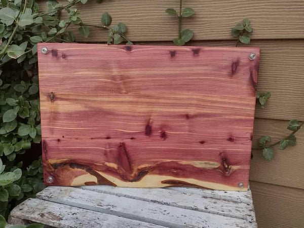 Red Cedar charcuterie board with heavy duty cast iron handles and clear rubber grip feet.