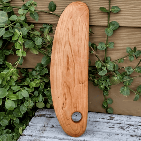 Side view showing cherry wood pizza cutter rocker edge and handle